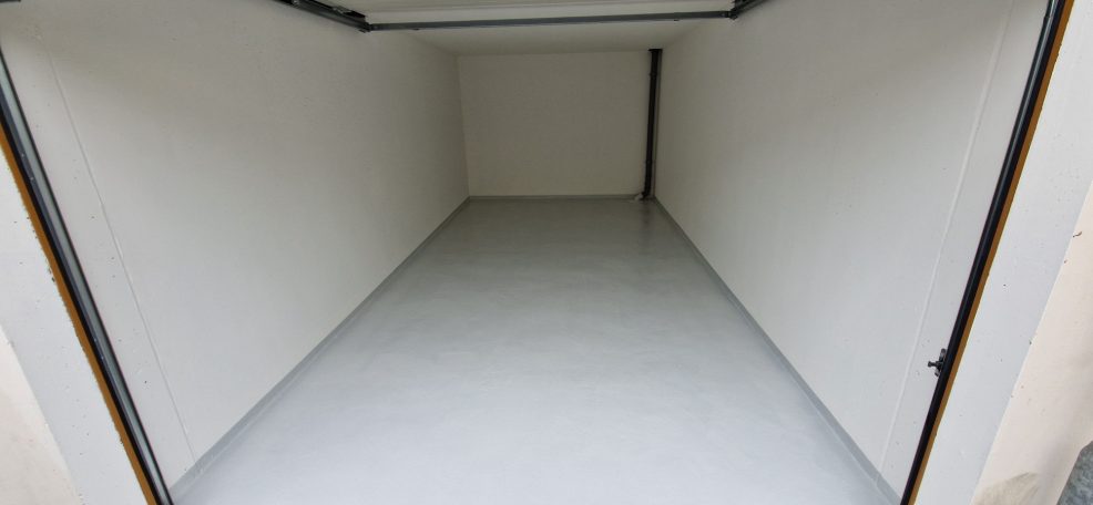 Ein leerer Raum mit weißen Wänden und glänzendem Boden, ohne Möbel oder Dekoration.